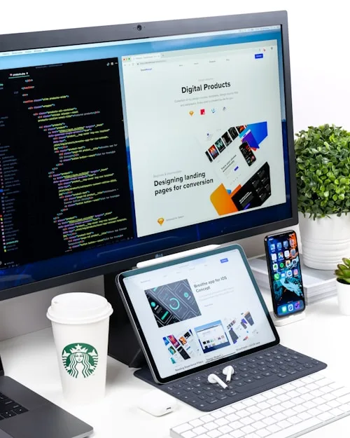 A modern workspace shows a computer, tablet and smartphone used for creative arts training.